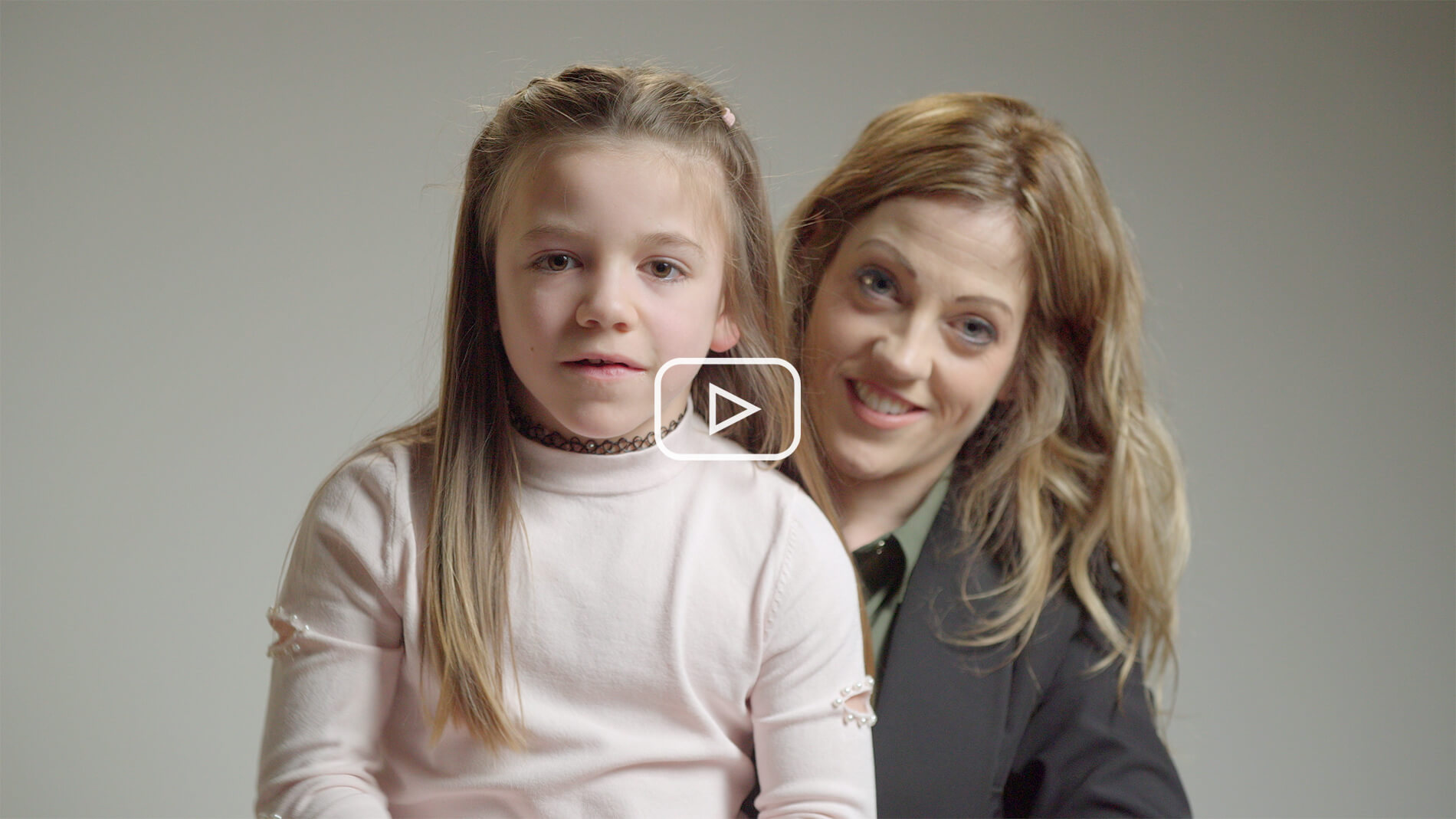 Still image from Turner Syndrome awareness video of Turner Syndrome girl sat on chair looking at camera